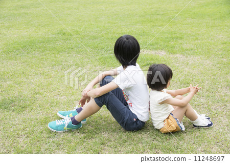 图库照片: 双臂抱膝坐于地板上 背靠背 不和