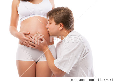 Happy young father kissing belly of pregnant wife Happy young father kissing belly of pregnant wife 11257931
