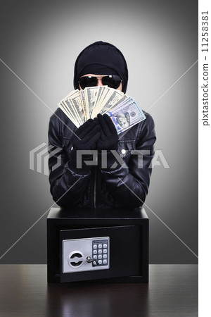 Thief holding dollars 11258381