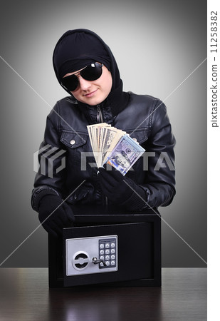 Thief holding a stolen dollars 11258382