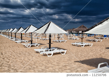 Different parasols and sun loungers on the empty beach on Tavira 11258706