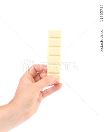 Hand holds white chocolate bar with filling. 11265733