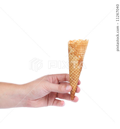 Hand holds empty ice cream cone. 11267040