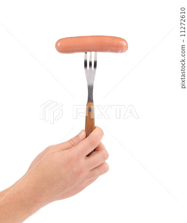 Raw sausage on a fork in hand. Raw sausage on a fork in hand. 11272610