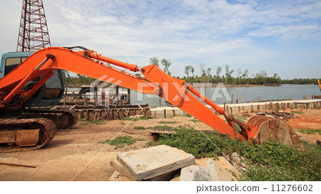 Heavy earth mover dipping dirt 11276602