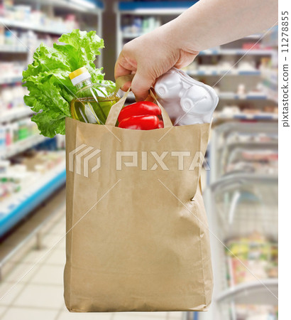 hand holding a paper bag with groceries 11278855