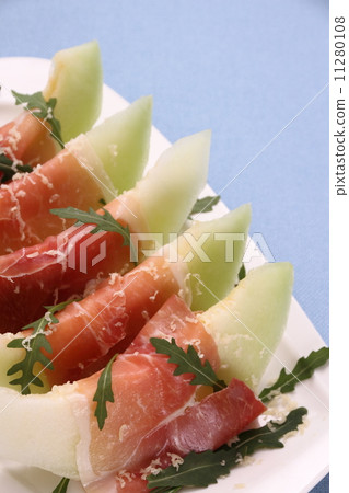 Ripe melon with ham, parmesan on white plate 11280108