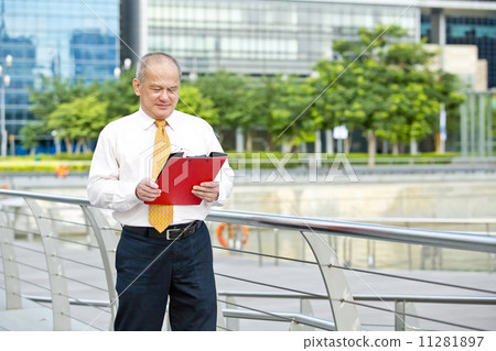 Senior business executive looking at red file Senior business executive looking at red file 11281897