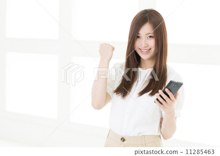 A woman watching a smartphone A woman watching a smartphone 11285463
