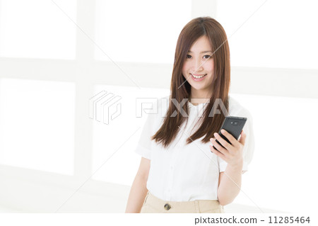 A woman watching a smartphone A woman watching a smartphone 11285464