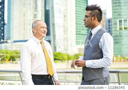 Young executive talking casually to senior executive Young executive talking casually to senior executive 11286345