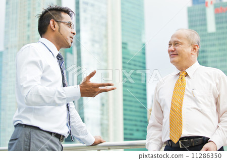 Young executive talking casually to senior executive 11286350