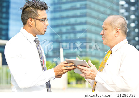 Young executive presenting to senior executive using tablet Young executive presenting to senior executive using tablet 11286355
