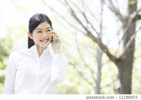 A woman talking with a smartphone outside 11290855