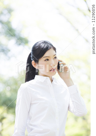 A woman talking with a smartphone outside 11290856
