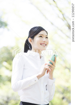 A woman who manipulates a smartphone outside 11290857