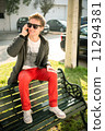 Young man sitting on a bench talking on the phone 11294381