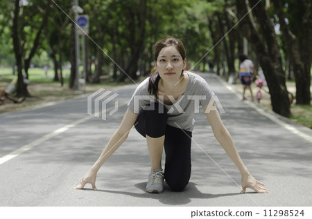Young asian woman ready to start running on the park 11298524