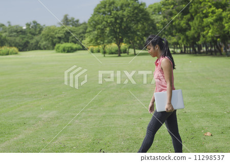 Female student outdoors holding laptop 11298537