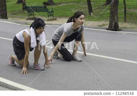 two young asian women ready to start running on the park two young asian women ready to start running on the park 11298538