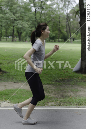 Jogging woman running in park. Sport fitness model of Asian trai Jogging woman running in park. Sport fitness model of Asian trai 11298540