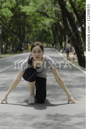 Young asian woman ready to start running on the park 11298633