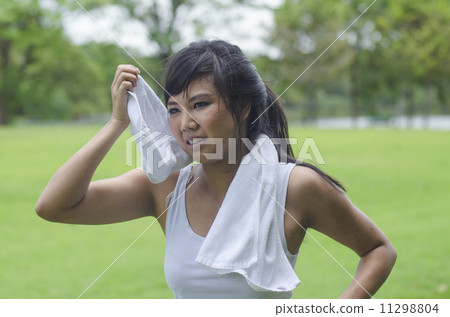 Asian woman wiping sweat with a towel after exercising 11298804