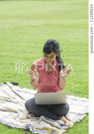 young attractive woman using laptop in the park 11298824