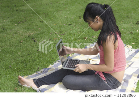 young attractive woman using laptop in the park 11298860