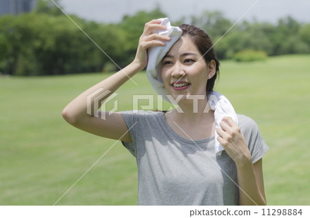 Asian woman wiping sweat with a towel after exercising Asian woman wiping sweat with a towel after exercising 11298884