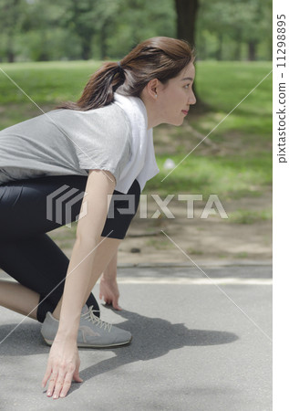 Young asian woman ready to start running on the park 11298895