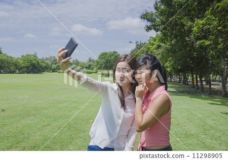 young beautiful Asian woman taking a self portrait with camera m young beautiful Asian woman taking a self portrait with camera m 11298905