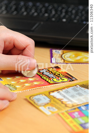 Scratching lottery tickets with computer background. Scratching lottery tickets with computer background. 11306340