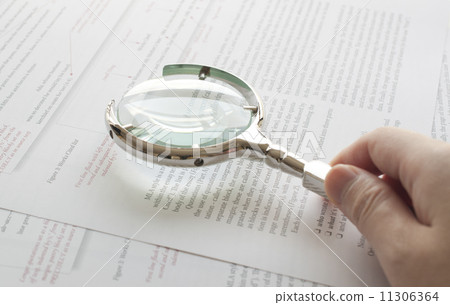 Hand holding magnifying glass to read document Hand holding magnifying glass to read document 11306364