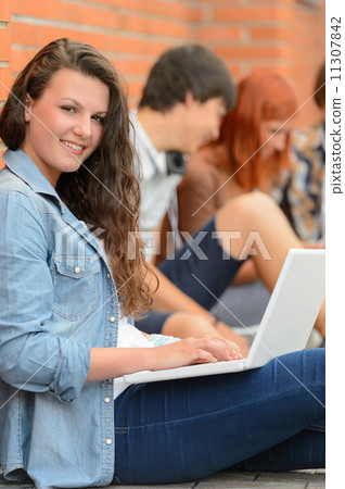 Girl working on laptop friends in background Girl working on laptop friends in background 11307842