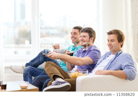 smiling friends with remote control at home smiling friends with remote control at home 11308620