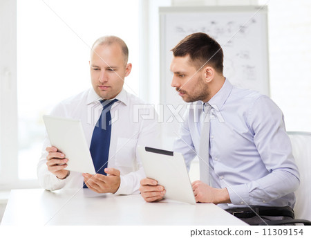 two serious businessmen with tablet pc in office two serious businessmen with tablet pc in office 11309154