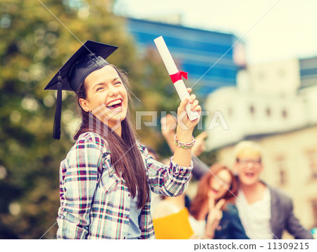 smiling teenage girl in corner-cap with diploma 11309215
