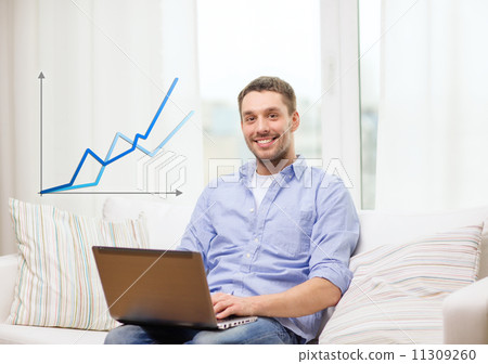smiling man working with laptop at home 11309260