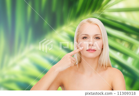 calm young woman pointing at her cheek calm young woman pointing at her cheek 11309318