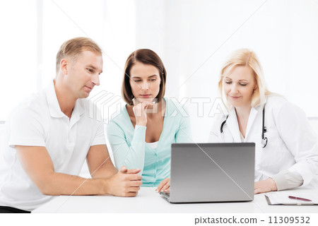 doctor with patients looking at laptop 11309532