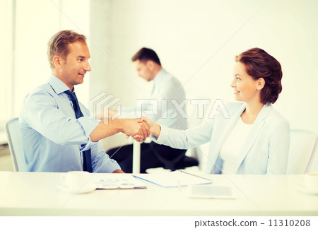 man and woman shaking hands in office 11310208