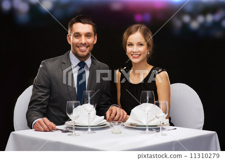 smiling couple holding hands at restaurant 11310279
