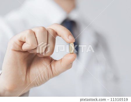 doctor hand showing one capsule doctor hand showing one capsule 11310519