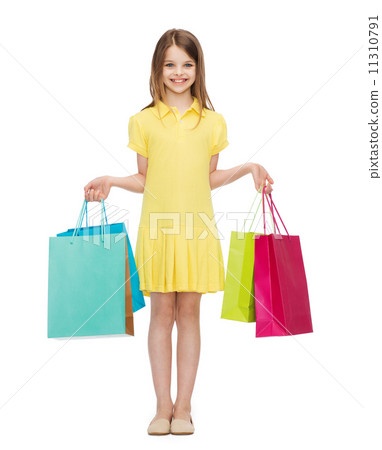 smiling little girl in dress with shopping bags 11310791