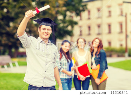 smiling teenage boy in corner-cap with diploma 11310841