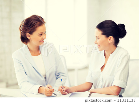 two businesswomen having discussion in office two businesswomen having discussion in office 11311135