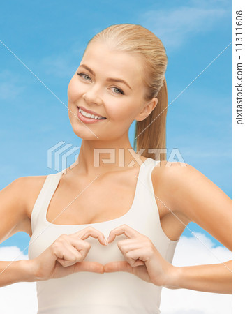smiling woman showing heart shape gesture 11311608