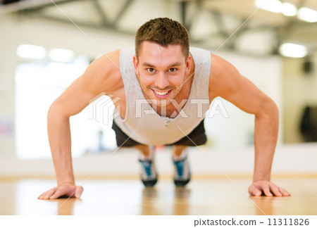 smiling man doing push-ups in the gym