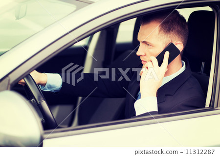 man using phone while driving the car 11312287